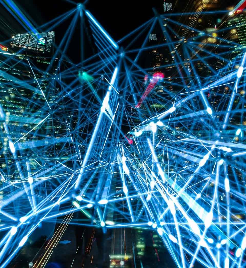 DQE Hero Night view of modern high rise building with an overlay of illuminated interconnected lines
